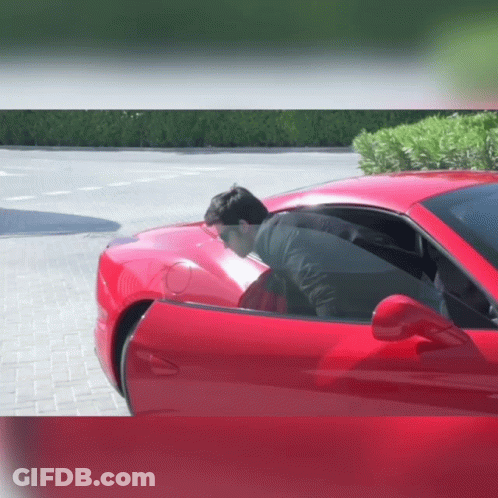Man In Black Jacket Sitting In Red Car GIF