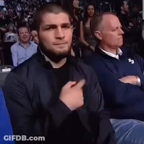 Man In Black Jacket Sitting With Man In Blue Jacket GIF