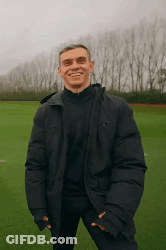 Man In Black Jacket Smiling In Field GIF