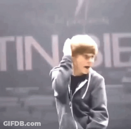 Man In Black Jacket Standing Before Tinibie Sign GIF