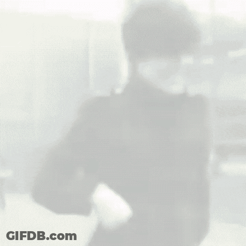 Man In Black Jacket Standing In Front Of Building GIF