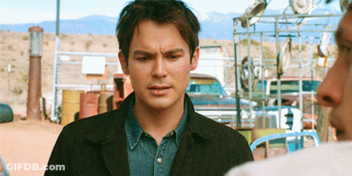 Man In Black Jacket Standing In Front Of Fence GIF