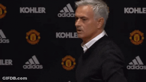 Man In Black Jacket Standing In Front Of Kohler And Adidas Banner GIF