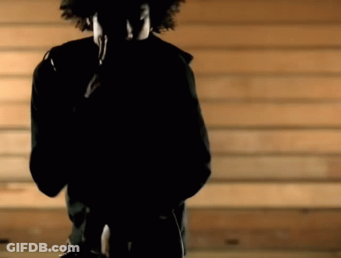 Man In Black Jacket Standing In Front Of Wood Wall GIF