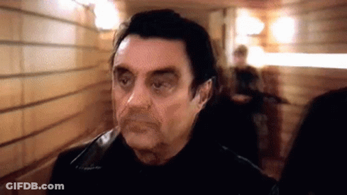 Man In Black Jacket Standing In Hallway GIF