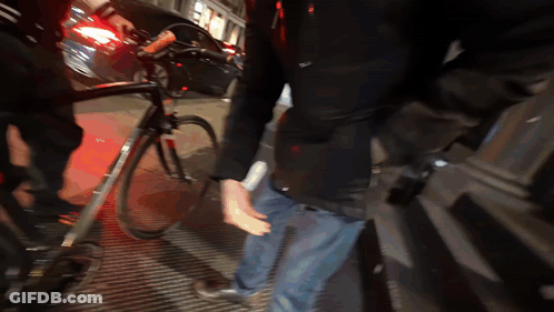 Man In Black Jacket Standing Next To Bicycle GIF