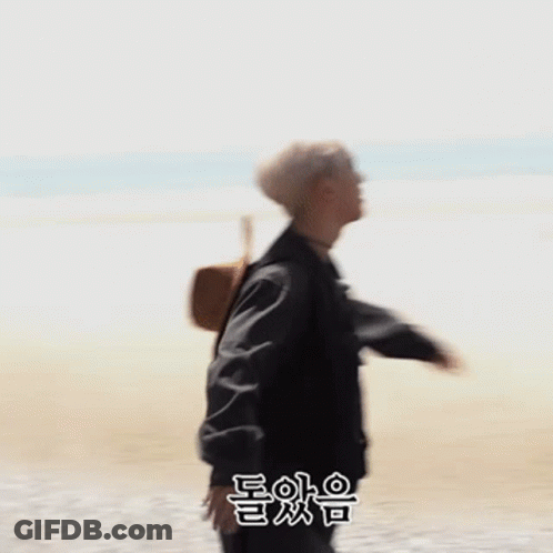 Man In Black Jacket Standing On Beach GIF