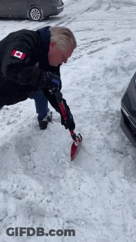 Man In Black Jacket With Canadian Flag Shoveling Snow GIF
