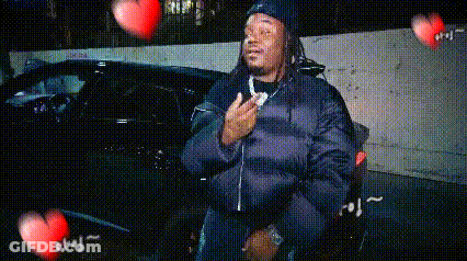 Man In Black Jacket With Flying Hearts GIF