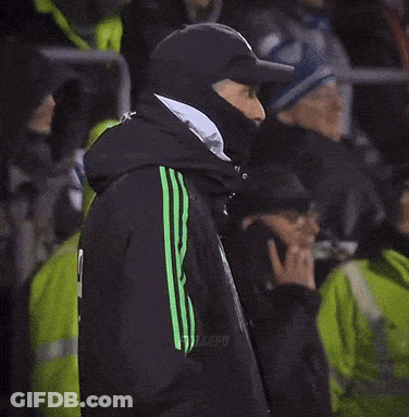 Man In Black Jacket With Green Stripes In Crowd GIF