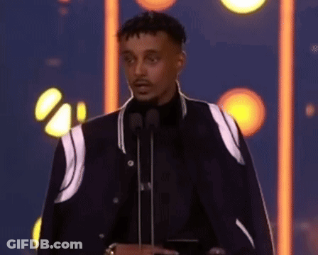 Man In Black Jacket With Two Microphones GIF