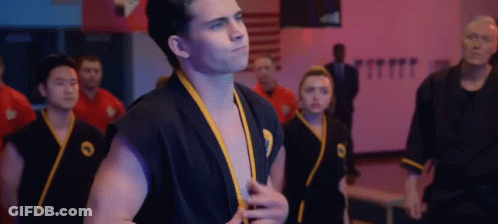 Man In Black Karate Uniform In Gym GIF