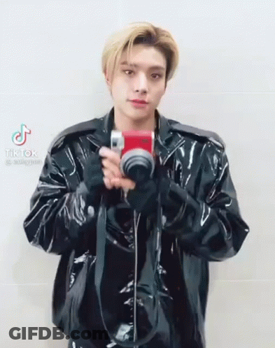 Man In Black Leather Jacket Holding Camera GIF