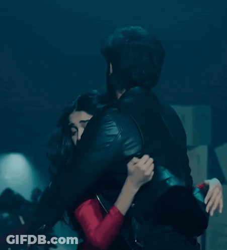 Man In Black Leather Jacket Hugging Woman In Red Dress GIF