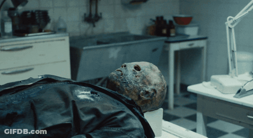 Man In Black Leather Jacket Lying On Table In Dark Room GIF