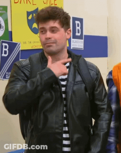 Man In Black Leather Jacket Standing In Front Of B Sign GIF
