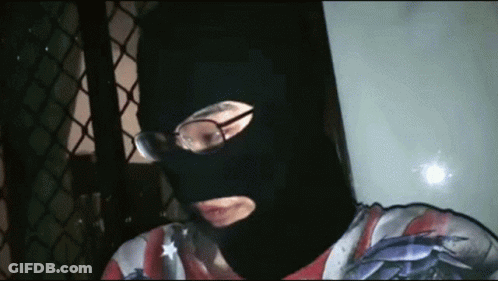 Man In Black Mask And Glasses Looking At Camera GIF