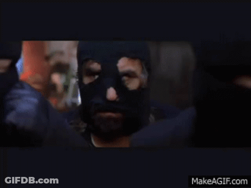 Man In Black Mask Standing Before Crowd GIF