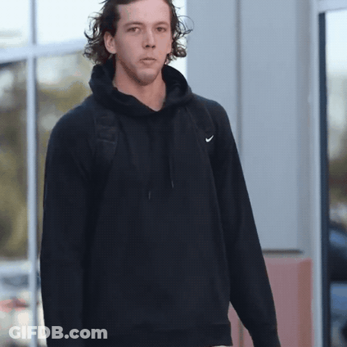 Man In Black Nike Hoodie Standing By Window GIF