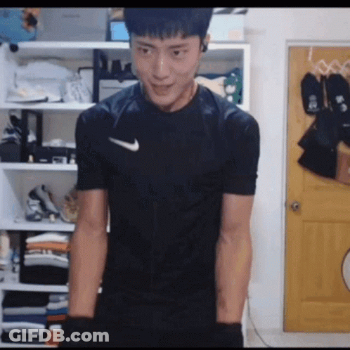 Man In Black Nike Shirt In Front Of Closet GIF