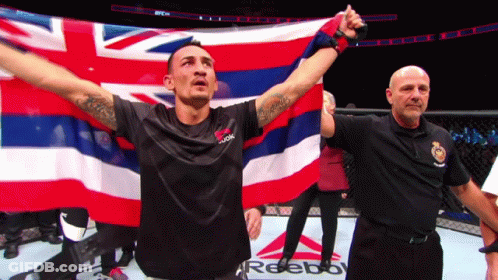 Man In Black Reebok Shirt Holding Hawaiian Flag GIF