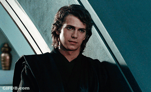 Man In Black Robe In Front Of Blue Wall GIF