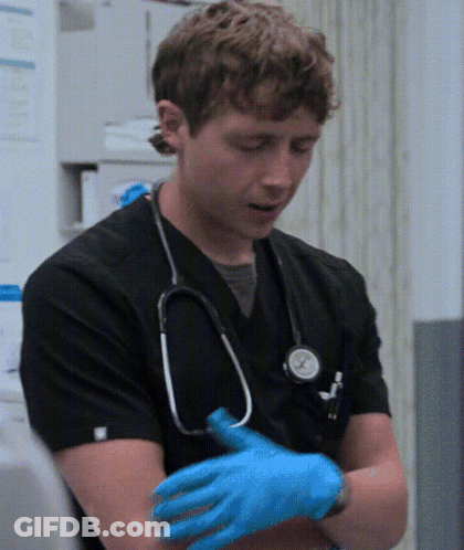 Man In Black Scrub With Stethoscope Putting On Blue Gloves GIF