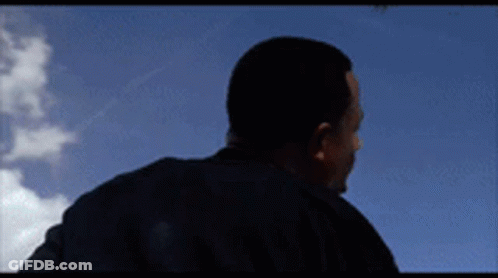 Man In Black Shirt Against Blue Sky Clouds GIF