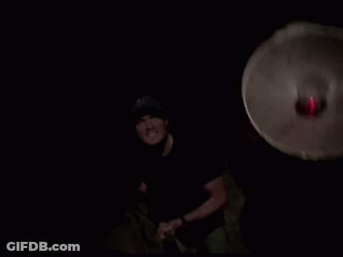 Man In Black Shirt And Blue Hat With Red Light Behind GIF