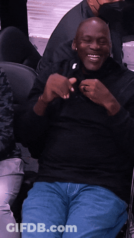 Man In Black Shirt And Blue Jeans Smiling In Chair GIF