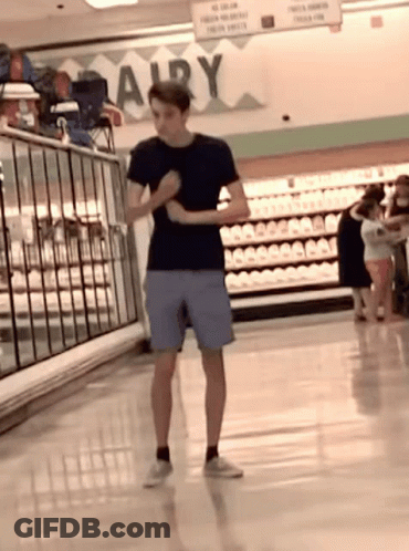 Man In Black Shirt And Blue Shorts At Dairy Sign GIF