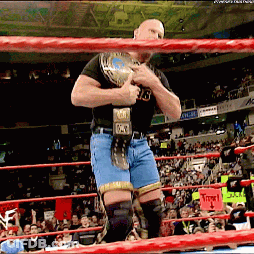 Man In Black Shirt And Blue Shorts Holding Wrestling Belt Number 13 GIF