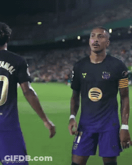 Man In Black Shirt And Purple Shorts Kneeling On Soccer Field GIF