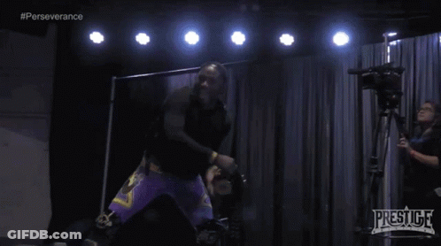 Man In Black Shirt And Purple Shorts With Prestige Camera GIF