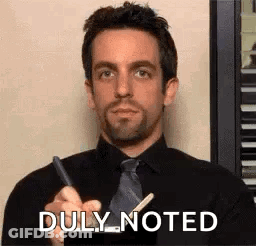 Man In Black Shirt And Tie Holding Pen And Stick GIF