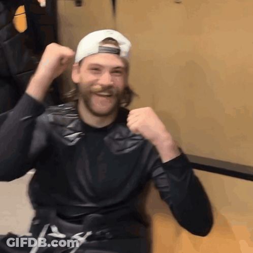 Man In Black Shirt And White Hat Raising Fist GIF