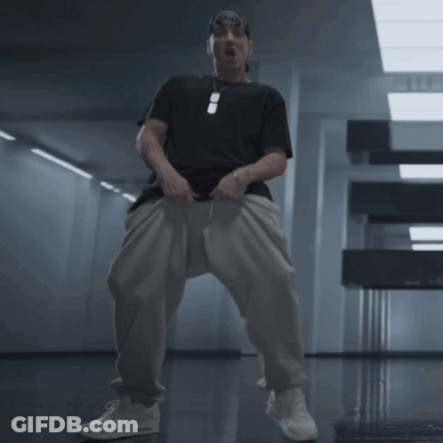 Man In Black Shirt And White Pants In Hallway GIF