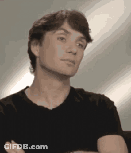 Man In Black Shirt Arms Crossed Looking At Camera GIF