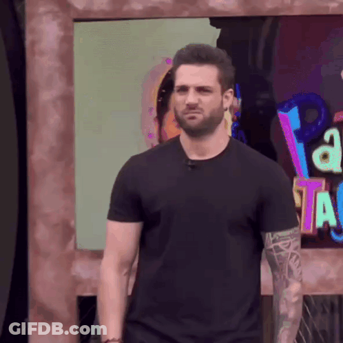 Man In Black Shirt At Sign Saying A GIF