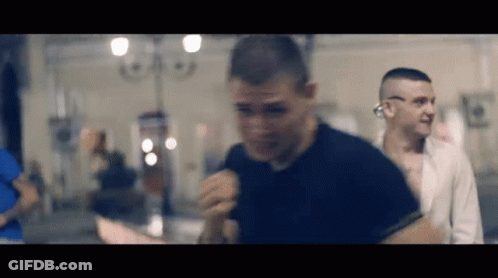 Man In Black Shirt Before Crowd In Dark Room GIF