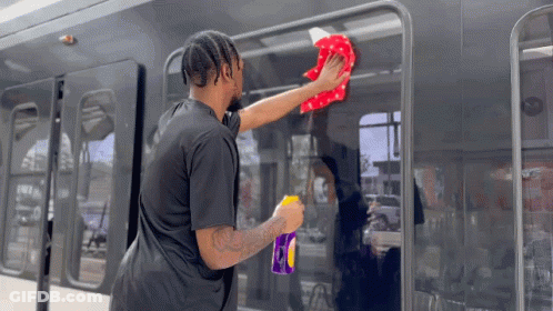 Man In Black Shirt Cleaning Bus With Cloth GIF
