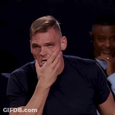 Man In Black Shirt Covering Mouth In Front Of Group GIF