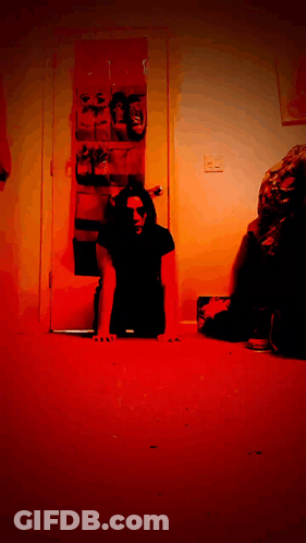 Man In Black Shirt Crawling On Floor In Dark Room GIF