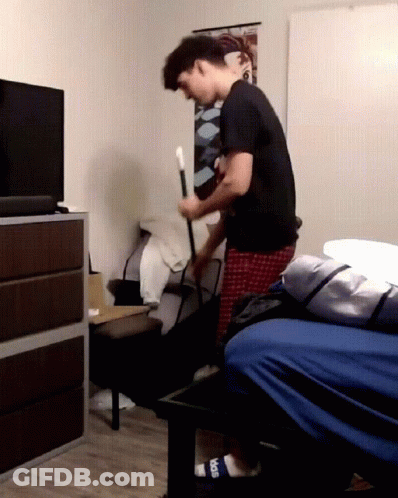 Man In Black Shirt Holding Cane In Bedroom GIF