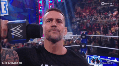 Man In Black Shirt Holding Microphone With W GIF