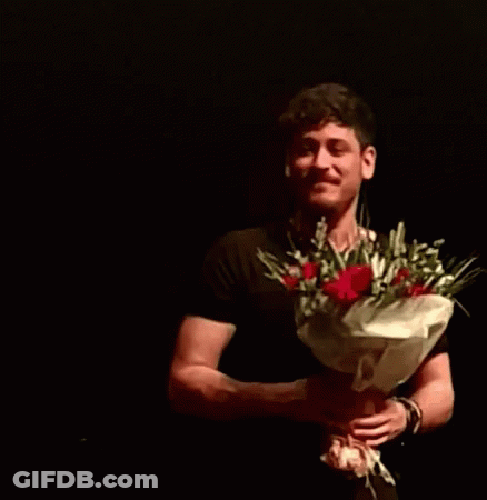 Man In Black Shirt Holding Red Roses GIF