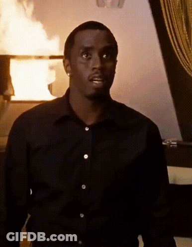 Man In Black Shirt In Front Of Burning Building GIF