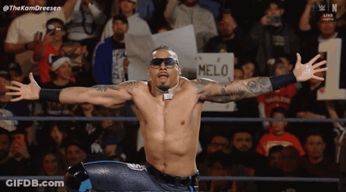 Man In Black Shirt In Front Of Carmelo Hayes Sign GIF