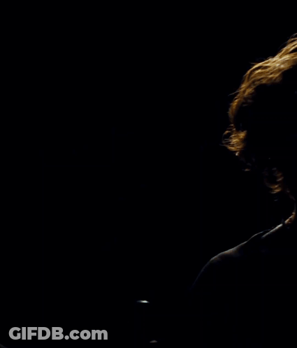 Man In Black Shirt In Front Of Circle In Dark GIF
