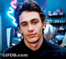 Man In Black Shirt In Front Of Neon Sign GIF